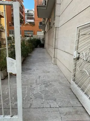 a stone walkway next to a building with a bench at Gianicolo House in Rome