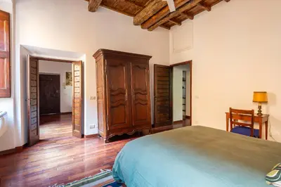 a bedroom with a bed and a wooden floor at Trastevere Lungaretta apartment in Rome