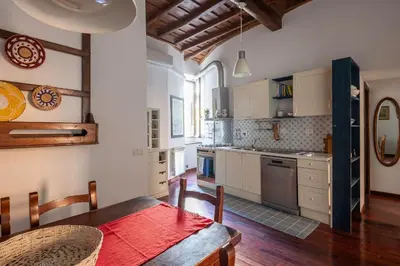 a kitchen with a wooden table and a kitchen with a tableablish at Trastevere Lungaretta apartment in Rome