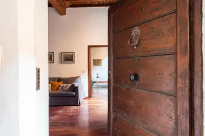 a wooden door in a living room with a couch at Trastevere Lungaretta apartment in Rome