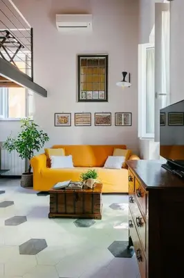 a living room with a yellow couch and a table at Charming restored loft in the heart of Trastevere in Rome