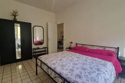 a bedroom with a bed with pink pillows and a mirror at R home of art in Rome
