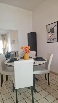 a dining room with a white table and white chairs at R home of art in Rome