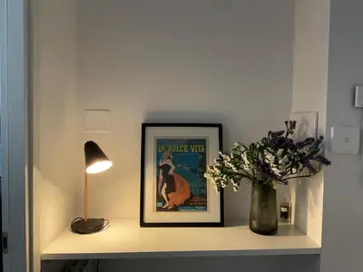 a shelf with a picture and a vase of flowers at CoolStayPigneto in Rome