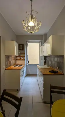 a kitchen with a chandelier and a kitchen with white cabinets at Appartamento C9 in Rome