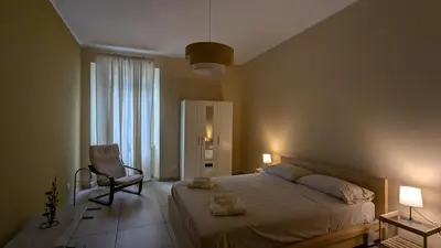 a bedroom with a large bed and a chair at Appartamento C9 in Rome