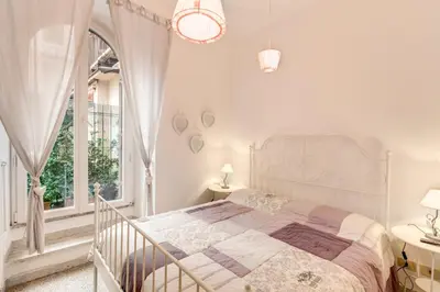 a white bedroom with a large bed and a window at Casa Dolce Casa in Rome