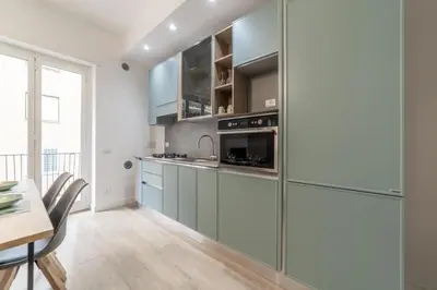 a kitchen with stainless steel appliances and a dining table at Domus 124, elegant city Comfort with Parking in Rome