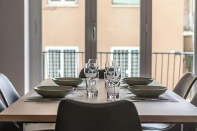 a wooden table with bowls and wine glasses on it at Domus 124, elegant city Comfort with Parking in Rome
