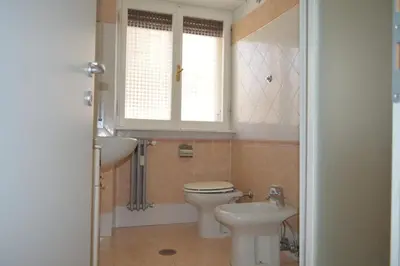 a bathroom with a toilet and a sink and a window at Fem House in Rome
