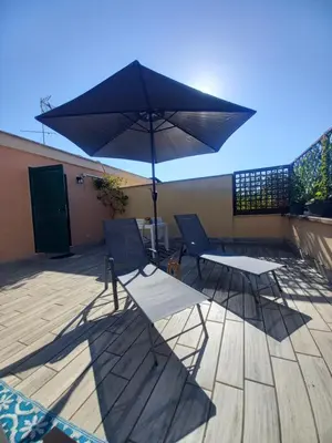 two chairs and a table and an umbrella on a patio at Monteverde Rhome in Rome