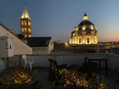 a view of a building with a clock tower at night at G&A Rome House in Rome