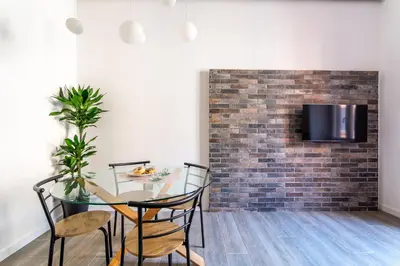 a dining room with a table and chairs and a brick wall at iFlat Radiant retreat in Esquilino in Rome