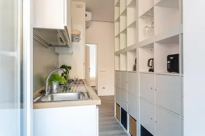 a kitchen with a sink and white cabinets at iFlat Radiant retreat in Esquilino in Rome