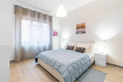a white bedroom with a bed and a window at La Casa di Aimara in Rome