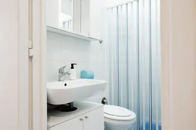 a white bathroom with a sink and a toilet at Montagnola Mini House in Rome