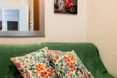 a green couch with a pillow and a mirror at Montagnola Mini House in Rome
