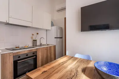 a kitchen with a wooden table and a counter top at iFlat Colosseum's Brand New & Cozy Nest in Rome
