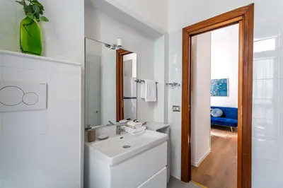 a white bathroom with a sink and a mirror at iFlat Colosseum's Brand New & Cozy Nest in Rome