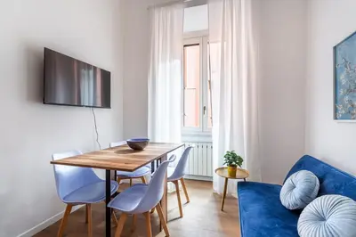 a dining room with a wooden table and blue chairs at iFlat Colosseum's Brand New & Cozy Nest in Rome