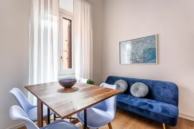 a living room with a blue couch and a wooden table at iFlat Colosseum's Brand New & Cozy Nest in Rome