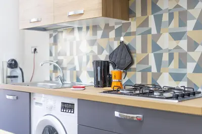 a kitchen with a stove and a washing machine at Amora Apartments in Rome
