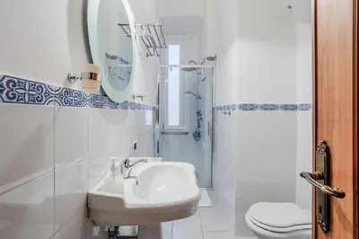 a white bathroom with a sink and a shower at La Casa Viola in Rome