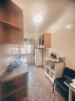 a kitchen with a refrigerator and a counter top at Betty House Roma in Rome