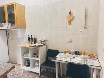 a kitchen with a table and two chairs and a counter at Betty House Roma in Rome