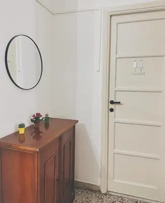 a room with a door and a table with a mirror at Betty House Roma in Rome