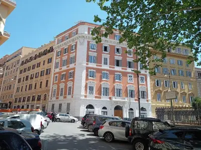 a large building with cars parked in a parking lot at Epic Home in Rome