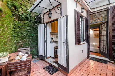 an outdoor patio with a table and a kitchen at Trastevere Cottage in Rome