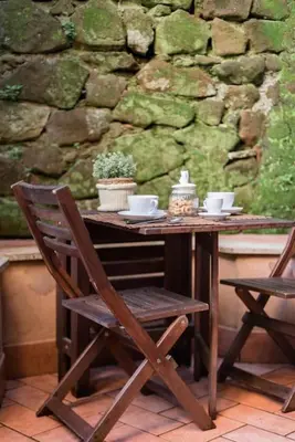 a wooden table with cups and saucers on it at Trastevere Cottage in Rome
