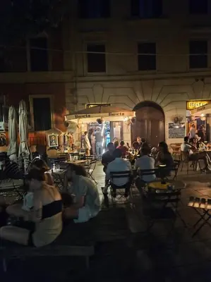 a group of people sitting at tables in a restaurant at night at Roma Sweet Dreams casa vacanze in Rome