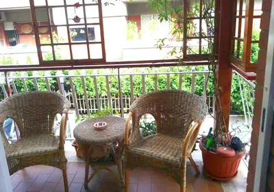 a porch with three chairs and a table and a table at La casa Bomboniera in Rome