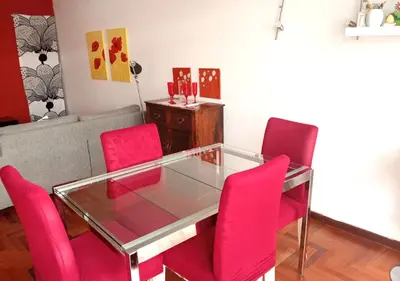 a dining room with pink chairs and a glass table at La casa Bomboniera in Rome