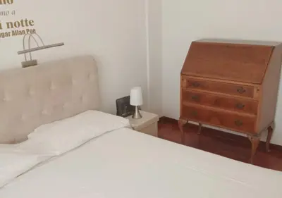a bedroom with a white bed and a dresser at La casa Bomboniera in Rome