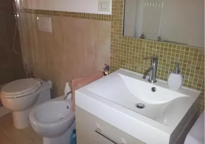 a bathroom with a white sink and a toilet at La casa Bomboniera in Rome