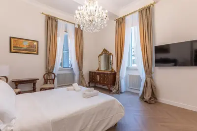 a bedroom with a bed and a mirror and a chandelier at Vista su Campo de Fiori in Rome