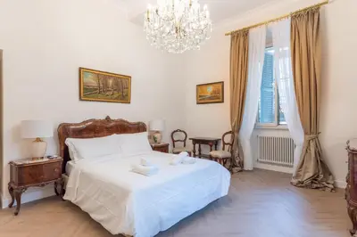 a bedroom with a white bed and a chandelier at Vista su Campo de Fiori in Rome