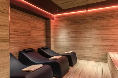 a sauna with two chairs in a room with wooden walls at Adoro Hotel in Rome