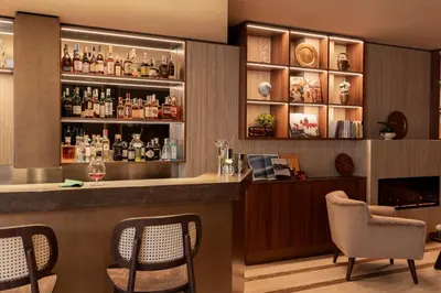 a bar in a hotel room with a counter and chairs at Adoro Hotel in Rome