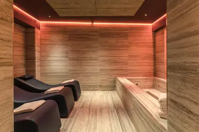 a sauna with benches in a room with wooden walls at Adoro Hotel in Rome