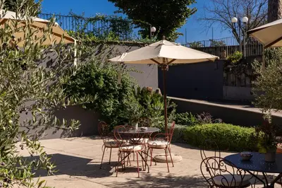 a patio with a table and chairs and an umbrella at Adoro Hotel in Rome