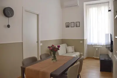 a living room with a table with a vase of flowers on it at RoMa Apt In Vatican in Rome
