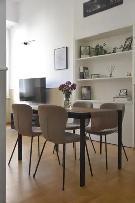 a dining room with a black table and chairs at RoMa Apt In Vatican in Rome