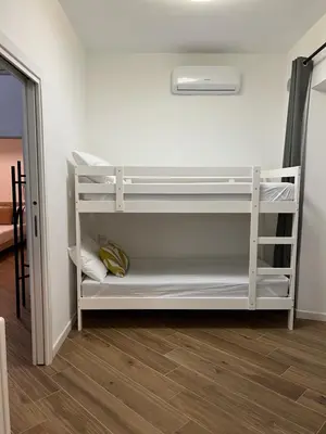 a white bunk bed in a room with wooden floors at Civico26 in Rome