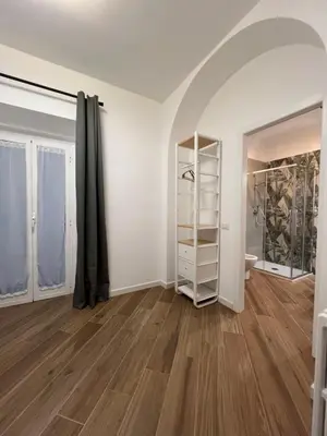 an empty room with white walls and wooden floors at Civico26 in Rome