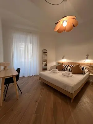 a bedroom with a bed and a table and a chandelier at Civico26 in Rome