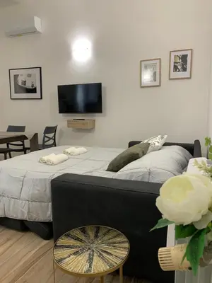 a bedroom with a large bed with a tv on the wall at Casa di Azzurra in Rome
